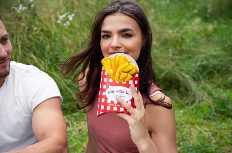 Fast foods that are healthy – a girl holding a box of socks resembling french fries